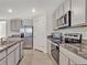 Modern kitchen featuring stainless steel appliances, granite countertops, and ample cabinet space at 5456 Logan Cave Ave, Wimauma, FL 33598