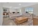 Bright living room with plush sofas, a wooden coffee table, and an open view to the kitchen and dining area at 5456 Logan Cave Ave, Wimauma, FL 33598