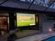 Inviting outdoor living space with a projector screen for entertainment, adjacent to a sparkling pool at 6605 Seabird Way, Apollo Beach, FL 33572