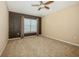 A beige carpeted bedroom with a ceiling fan and a window at 7001 Interbay Blvd # 181, Tampa, FL 33616