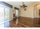 This is a living room with hardwood floors, a ceiling fan, a chair, and a glass door leading to a balcony at 7001 Interbay Blvd # 181, Tampa, FL 33616