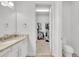 Bright bathroom with double sinks, granite counters, and walk-in closet at 704 Winterside Dr, Apollo Beach, FL 33572