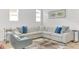 Bright living room featuring a modern sectional, stylish decor, and ample natural light at 704 Winterside Dr, Apollo Beach, FL 33572