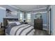 Stylishly furnished bedroom with blue accent wall, a wave art piece and calming neutral bedding at 757 Steel Dr, Apollo Beach, FL 33572