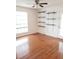 Spacious living room featuring hardwood floors, modern shelving, and a large window at 8728 Mallard Reserve Dr # 102, Tampa, FL 33614