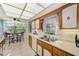 Cozy kitchen featuring wood-grain cabinets, white countertops, and stainless steel sink, complemented by a sunlit dining area at 1012 Pearce Dr # 101, Clearwater, FL 33764