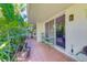 Tiled patio with tropical plants, seating, and sliding glass doors into the residence at 1012 Pearce Dr # 101, Clearwater, FL 33764