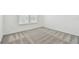 Bright bedroom featuring neutral carpet and white walls, illuminated by a window at 10356 Cross River Trl, Parrish, FL 34219
