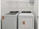 Laundry room with a modern white washing machine and dryer set, and wire shelf above at 10356 Cross River Trl, Parrish, FL 34219