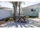 Cozy patio in the backyard with a wooden picnic table and lush greenery at 1044 Charles St, Clearwater, FL 33755