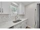 Bright kitchen features white cabinetry, stainless steel appliances, and lovely marble backsplash at 1044 Charles St, Clearwater, FL 33755