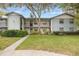 Two-story condo building with green lawn, sidewalk, and lush landscaping at 11800 Park Blvd # 505, Seminole, FL 33772