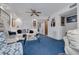 Comfortable living room featuring a ceiling fan, blue carpet, and ample natural light at 11800 Park Blvd # 505, Seminole, FL 33772