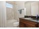 The bathroom features a shower over tub, a sink with storage, and a dark granite countertop at 11930 Perennial Pl, Bradenton, FL 34211