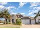 Beautiful home with a stone facade, paver driveway, tile roof, three-car garage, and lush landscaping at 11930 Perennial Pl, Bradenton, FL 34211