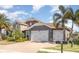 Beautiful home with a paver driveway, tile roof, three-car garage, stone accents, and lush landscaping at 11930 Perennial Pl, Bradenton, FL 34211