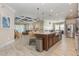Open-concept kitchen with a large island, seating, tile flooring, stainless steel appliances, and decorative pendant lighting at 11930 Perennial Pl, Bradenton, FL 34211