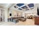 Comfortable living room featuring a coffered ceiling, tile floors, gray sectional, stylish decor, and an open concept at 11930 Perennial Pl, Bradenton, FL 34211