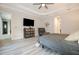 Serene main bedroom with a tray ceiling, luxury vinyl plank flooring, soft lighting, and minimalist decor at 11930 Perennial Pl, Bradenton, FL 34211