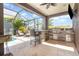 This screened in outdoor space has an outdoor kitchen, bar, and overlooks the swimming pool at 11930 Perennial Pl, Bradenton, FL 34211