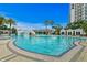 Large, resort-style pool with a waterfall, palm trees, and lush landscaping near high-rise buildings at 1209 E Cumberland Ave # 502, Tampa, FL 33602