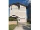 Two-story home featuring a private driveway and a charming covered entryway with lush landscaping at 13253 Boca Ciega Ave, Madeira Beach, FL 33708