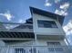 Shot of a two-story house with a large upper balcony and neutral siding at 13253 Boca Ciega Ave, Madeira Beach, FL 33708