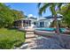 Backyard with a pool, patio area, and lush landscaping under a bright blue sky at 1389 47Th Ne Ave, St Petersburg, FL 33703