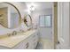 Bright bathroom with double sinks, a large mirror, and a shower with a glass door at 1389 47Th Ne Ave, St Petersburg, FL 33703