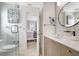 Well-lit bathroom with a white vanity, round mirror, tiled accent wall, and a partial view into bedroom at 1389 47Th Ne Ave, St Petersburg, FL 33703