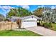 A single-story, white house with brick driveway, 2-car garage and a well-manicured green lawn at 1389 47Th Ne Ave, St Petersburg, FL 33703