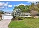 Charming single-story home featuring a brick driveway, two-car garage, lush lawn and mature landscaping at 1389 47Th Ne Ave, St Petersburg, FL 33703