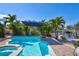 An inviting in-ground pool with brick surround and tropical landscaping, located on a waterfront canal at 1389 47Th Ne Ave, St Petersburg, FL 33703