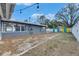 Backyard featuring a pea gravel area, white fencing, string lights, and a view of colorful sheds at 1416 55Th N Ave, St Petersburg, FL 33703