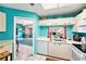 Bright kitchen overlooking the living area and featuring white appliances and blue walls at 15 Emerald Bay Dr, Oldsmar, FL 34677