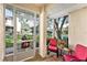 Screened lanai with red cushioned chairs overlooks a serene pond at 15 Emerald Bay Dr, Oldsmar, FL 34677