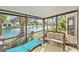 Relaxing screened lanai with lake view, chaise lounge and wicker furniture at 15 Emerald Bay Dr, Oldsmar, FL 34677