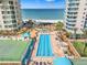 Overhead view of a community pool and tennis courts nestled between two high rise condominiums at 1560 Gulf Blvd # 1202, Clearwater Beach, FL 33767