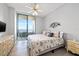 Inviting bedroom featuring a queen size bed, neutral walls, hardwood floors, ceiling fan, and balcony access at 1560 Gulf Blvd # 1202, Clearwater Beach, FL 33767