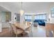 Dining area with a large table, modern chandelier, and access to the living room with ocean views at 1560 Gulf Blvd # 1202, Clearwater Beach, FL 33767