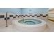 Relaxing hot tub area with a round jacuzzi, tiled surround, and safety rails at 1560 Gulf Blvd # 1202, Clearwater Beach, FL 33767