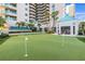 Putting green surrounded by lush greenery and towering palm trees at 1560 Gulf Blvd # 1202, Clearwater Beach, FL 33767