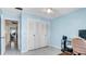 This bedroom features a large closet, light blue walls, neutral tile flooring and a ceiling fan at 1662 S Lake Ave # 2, Clearwater, FL 33756