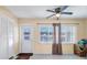 A bright living room is displayed, featuring a ceiling fan, neutral walls, and access to the exterior at 1662 S Lake Ave # 2, Clearwater, FL 33756