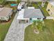 Aerial view of the home showcasing its well-manicured lawn, modern hardscape driveway, and colorful exterior at 1868 Douglas Ave, Dunedin, FL 34698
