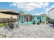 Backyard patio features outdoor seating, a screened-in porch, lush landscaping, and ample space for entertaining at 1868 Douglas Ave, Dunedin, FL 34698