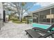 Inviting backyard features a stone patio, screened in porch, and relaxing lounge chairs at 1868 Douglas Ave, Dunedin, FL 34698