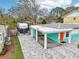 Charming home featuring a covered carport, colorful accent doors, and a paved driveway at 1868 Douglas Ave, Dunedin, FL 34698