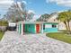 Charming home featuring a covered carport, colorful accent doors, and a paved driveway at 1868 Douglas Ave, Dunedin, FL 34698
