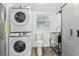 Well-organized laundry area with stacked washer/dryer and a stainless steel sink at 1868 Douglas Ave, Dunedin, FL 34698